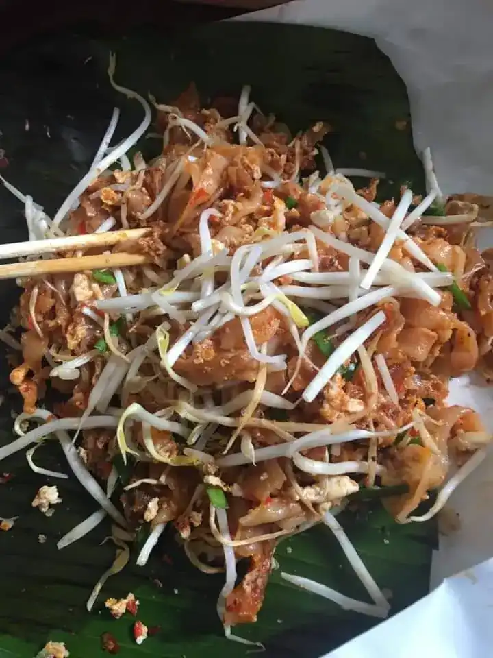 Flat noodles fried with bean sprouts, served on banana leaf