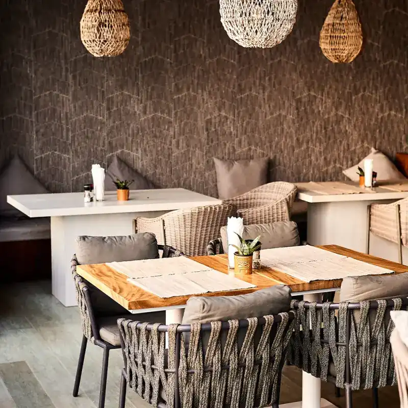 Dining tables with woven chairs and rattan lamps on the lower floor