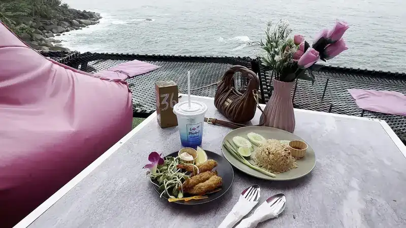 Spring rolls and fried rice on a table by the net, over the sea / ปอเปี๊ยะทอดและข้าวผัดบนโต๊ะริมตาข่าย เหนือทะเล