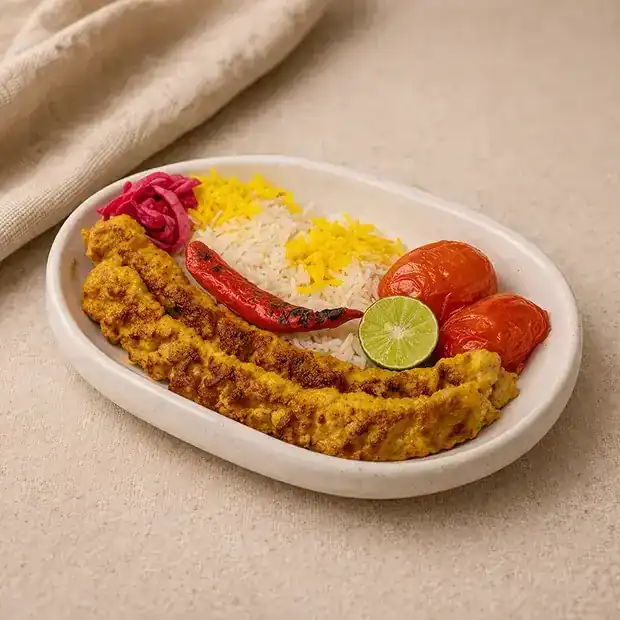 Chicken chelo kebab with rice, grilled tomatoes and a grilled chilli