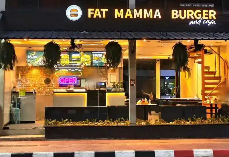 The shopfront at dusk with its sign lit: FAT MAMMA BURGER and cafe / หน้าร้านยามค่ำ ป้ายไฟ FAT MAMMA BURGER and cafe
