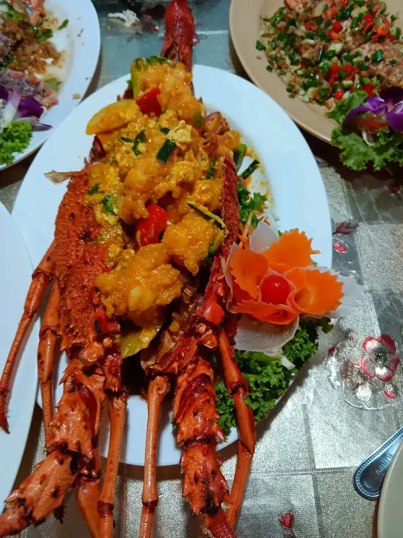 Lobster in a creamy yellow sauce with carved carrot and tomato