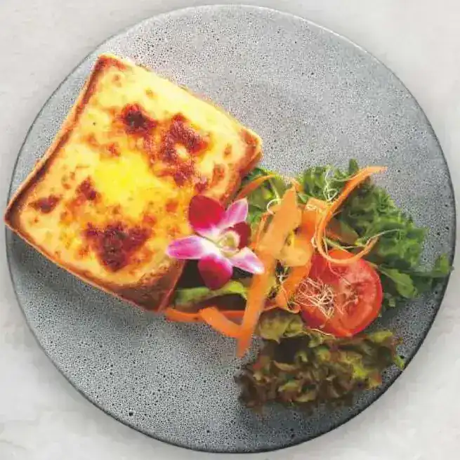 Croque monsieur with salad on a grey plate