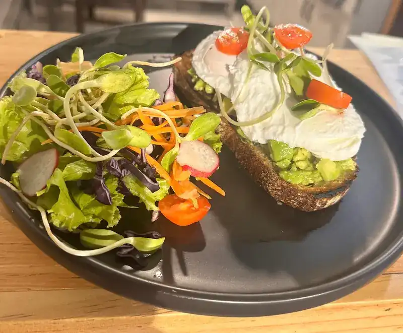 Avocado toast with a poached egg and a side salad