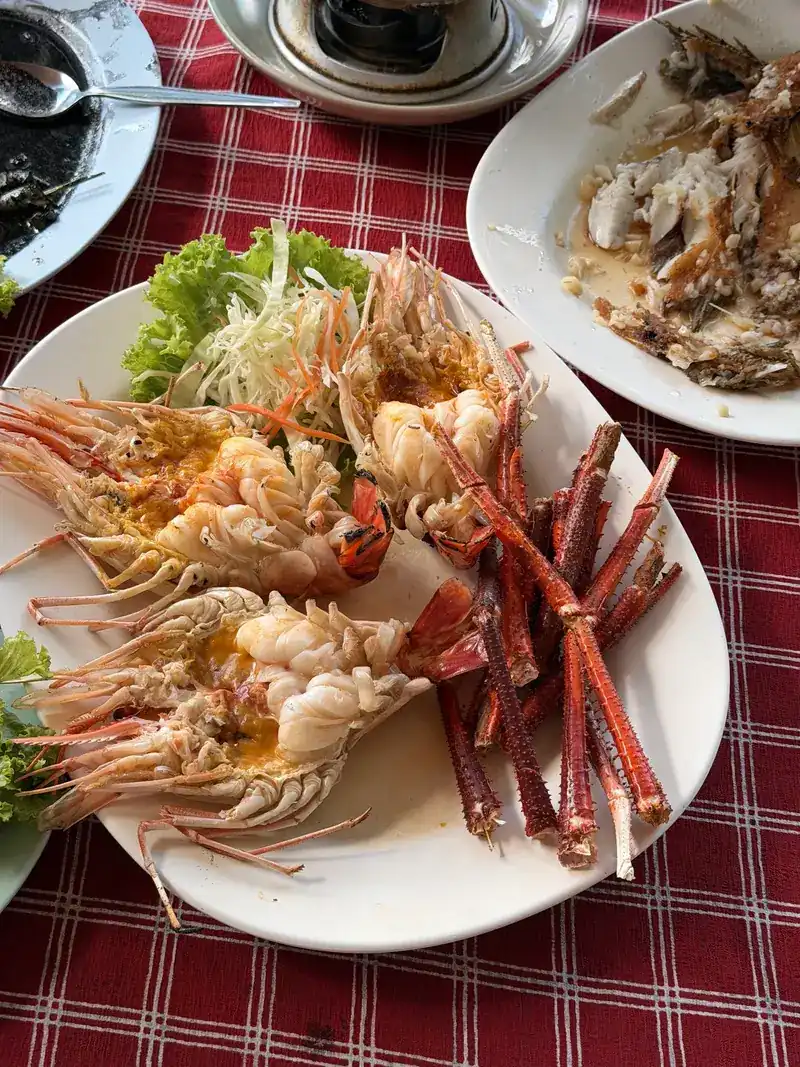 Large prawns split open on a white plate with lettuce / กุ้งตัวโตผ่าครึ่งบนจานสีขาว แต่งด้วยผักกาด