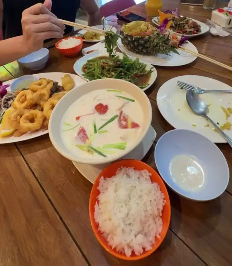 Tom kha in the middle of a shared table / ต้มข่าวางกลางโต๊ะกับอาหารจานอื่น