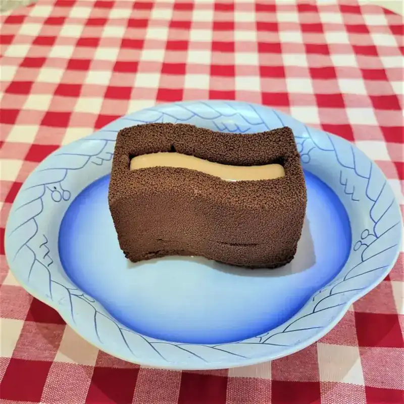 A chocolate and caramel mousse cake on a blue plate