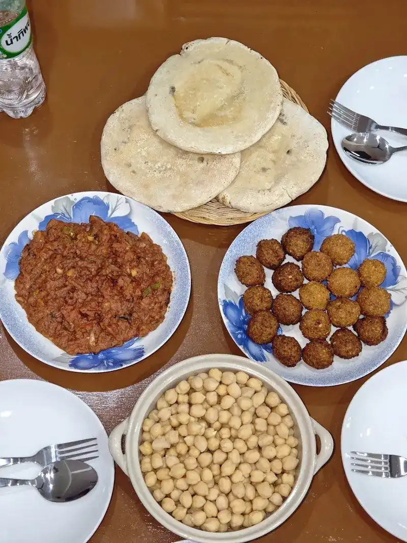 Falafel, chickpeas and fresh flatbread on blue-flowered plates