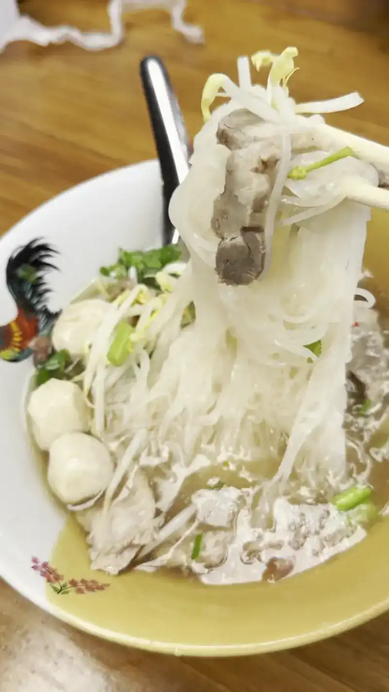 Rice noodles lifted from a rooster bowl / เส้นก๋วยเตี๋ยวคีบขึ้นจากชามตราไก่