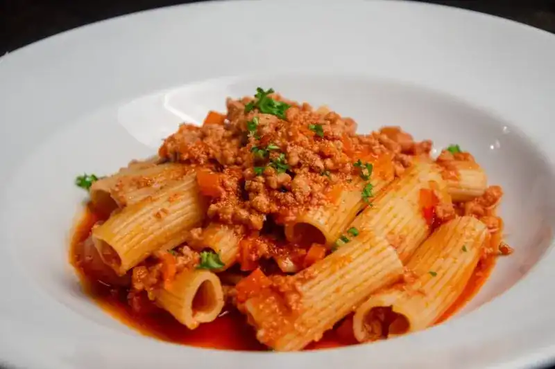 Rigatoni Bolognese in a white bowl