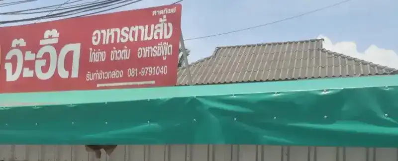 The shop's red sign above a green awning