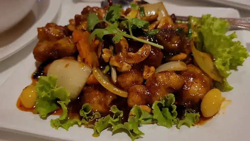 A stir-fry with cashew nuts, onion, dried chilli and coriander