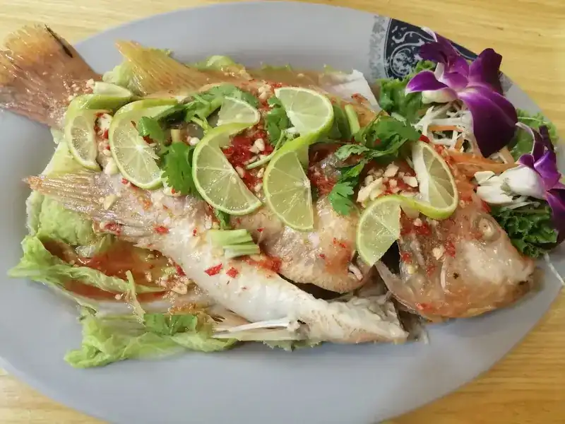 Whole fish, steamed, under lime slices, chilli and coriander