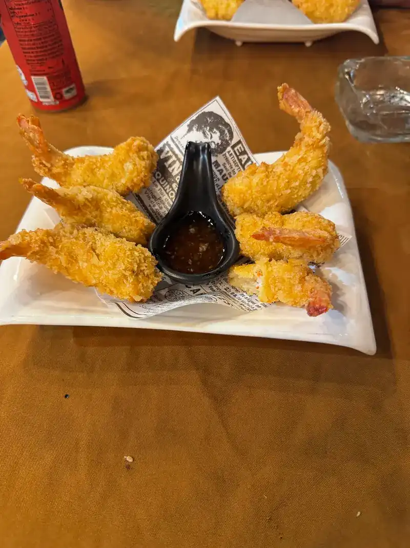 Golden fried prawns around a spoon of dipping sauce