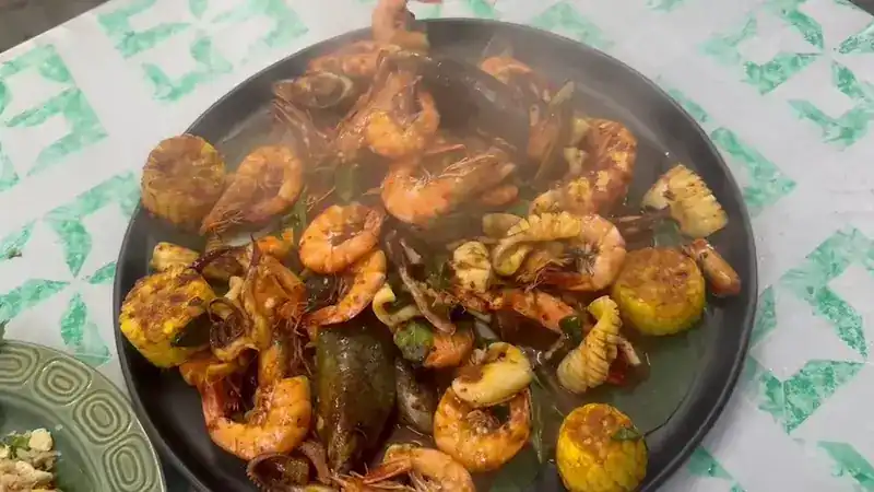 A big platter of prawns, squid, mussels and corn in a spiced sauce