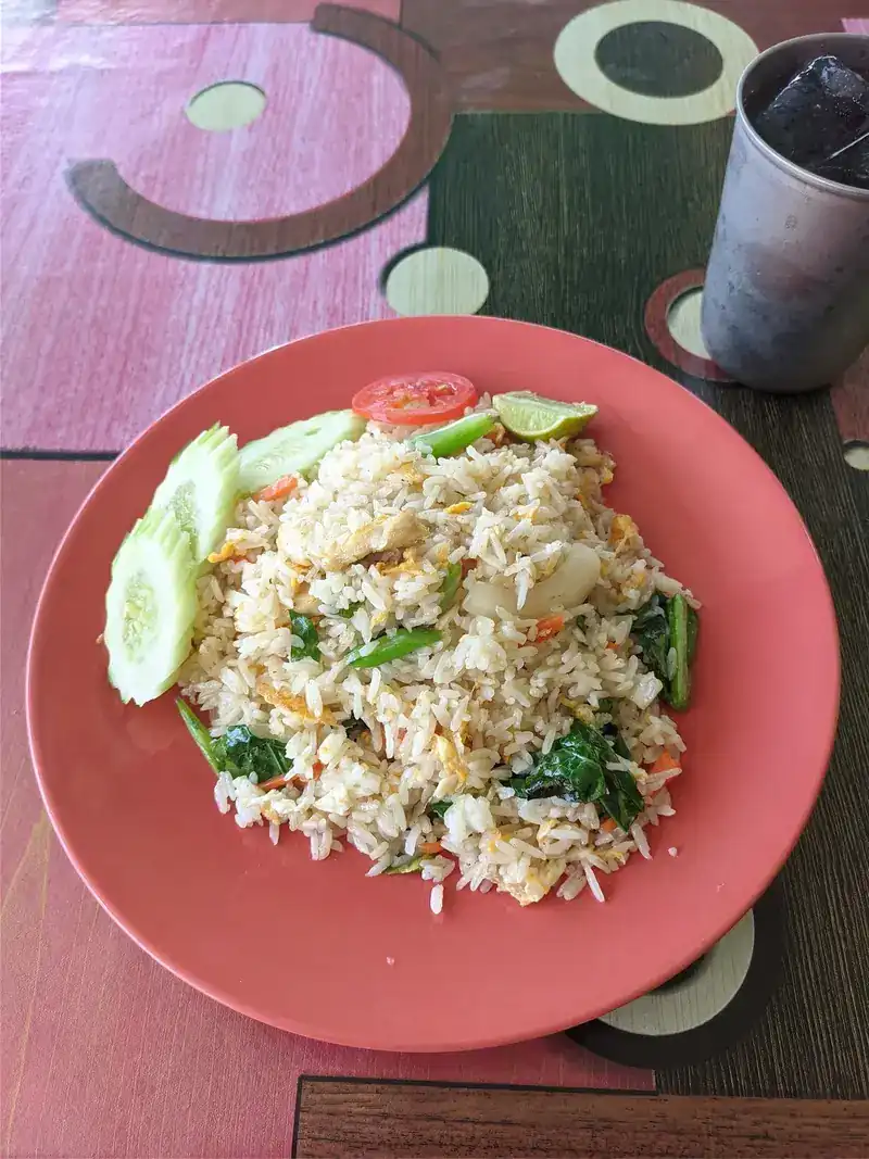 Fried rice with cucumber, tomato and lime on a pink plate
