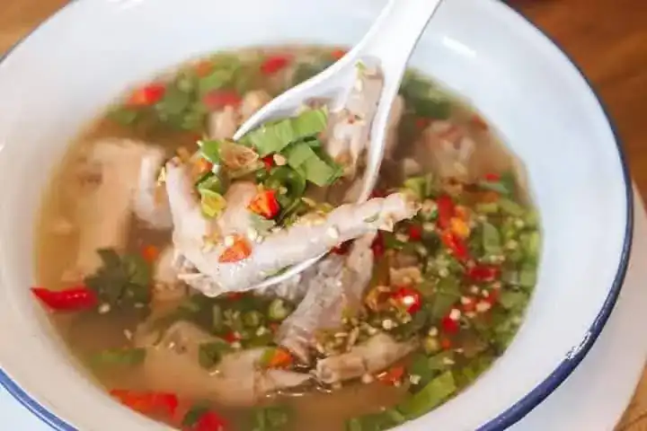 Spicy clear soup with chicken feet, chilli and herbs