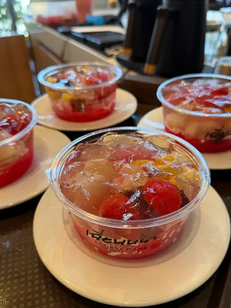 Bowls of O'aew with jelly and red syrup, on saucers at the counter