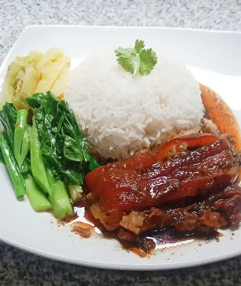 Rice with pork belly in a dark glossy sauce, Chinese kale and cabbage