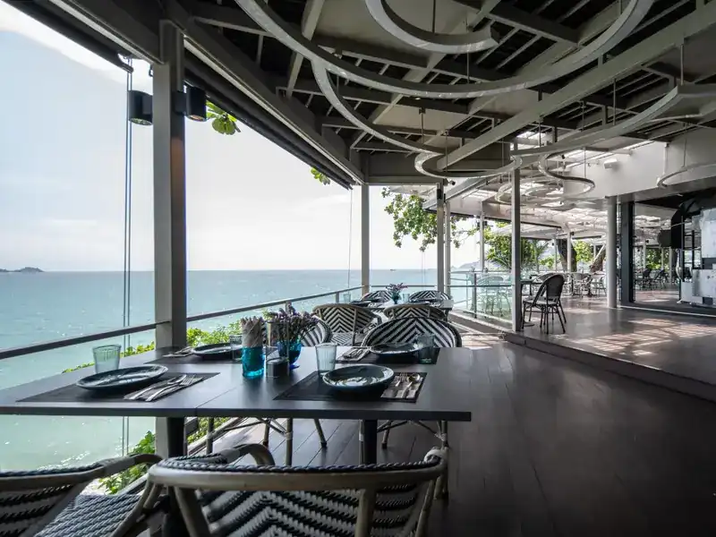 A table laid at the edge of the terrace, above the sea