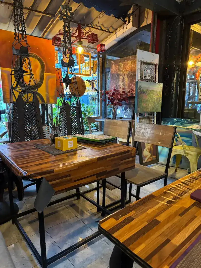 Corner table with wood-block tops under iron lanterns and paintings