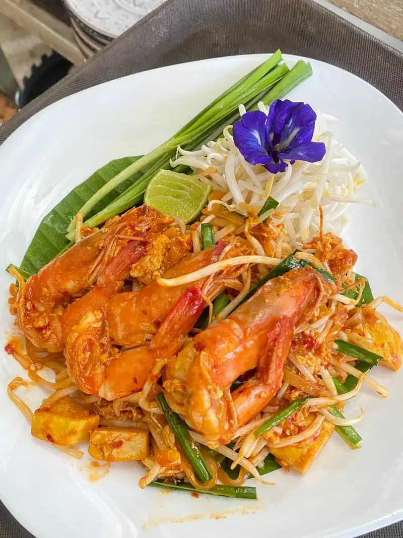 Pad thai with prawns and a butterfly pea flower / ผัดไทยกุ้ง แต่งด้วยดอกอัญชัน