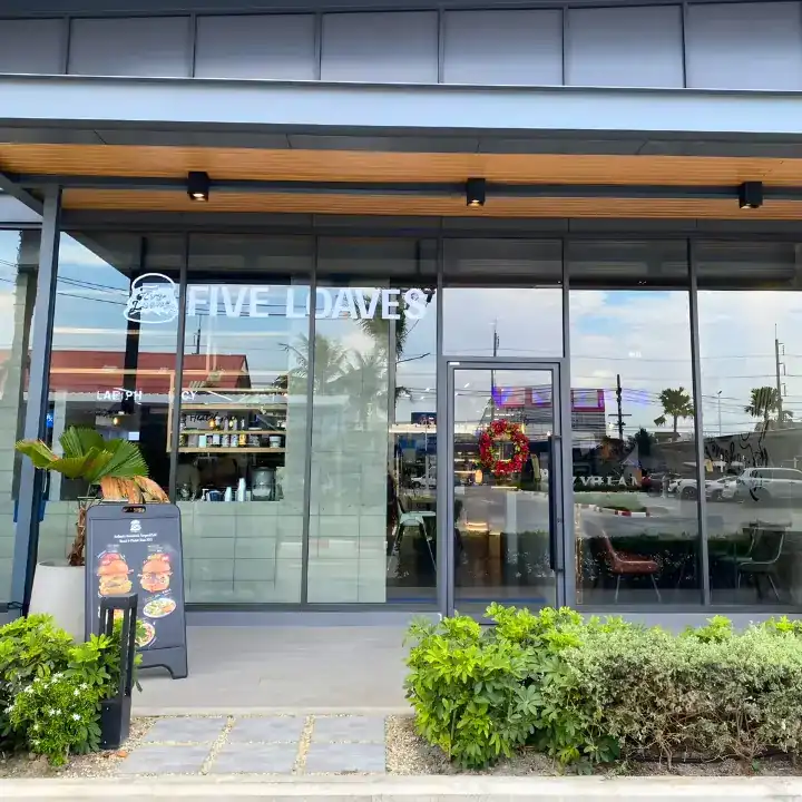 The Five Loaves shopfront with glass walls and planted beds
