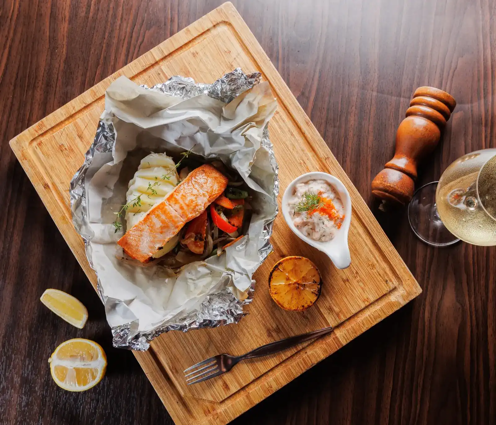 Salmon baked in foil with potato, served on a wooden board