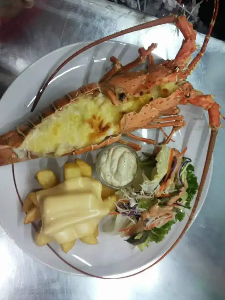 Grilled lobster under cheese with fries and salad