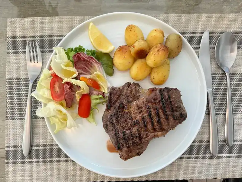 Grilled steak with roast potatoes and a side salad
