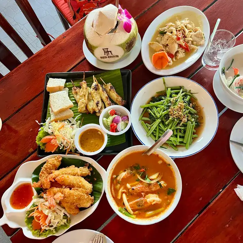 Satay on a banana leaf, morning glory, tom yum and more dishes seen from above