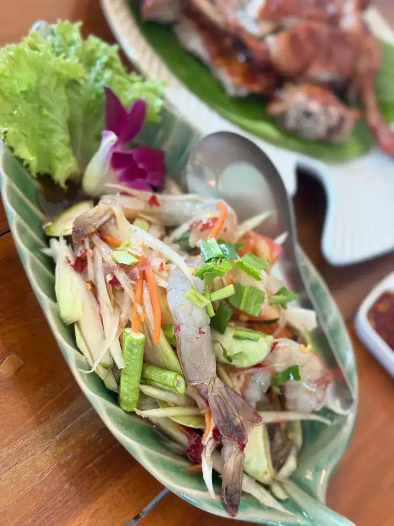 Papaya salad with prawns on a leaf-shaped plate
