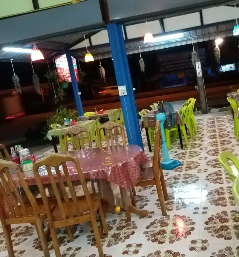 The terrace in the evening: wooden and green chairs, coloured lamps, blue posts / ลานร้านยามค่ำ เก้าอี้ไม้และเก้าอี้สีเขียว โคมไฟหลากสี เสาสีฟ้า
