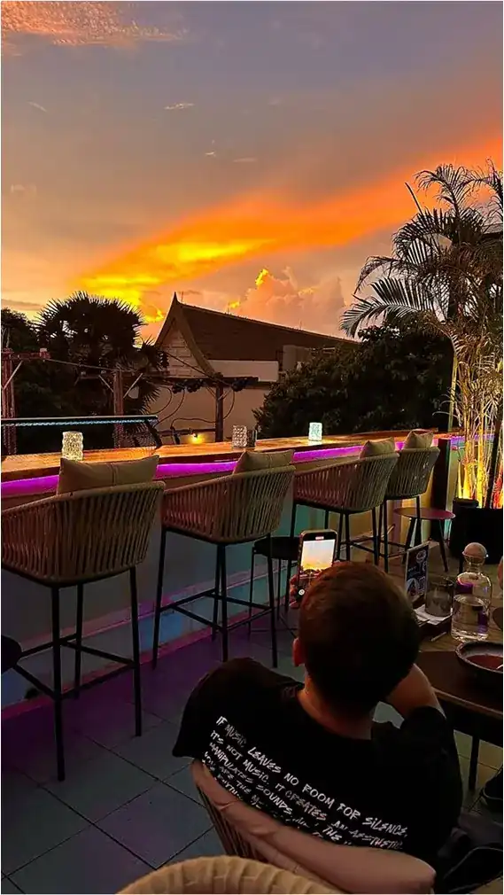 Sunset over the rooftop bar counter, lit violet from underneath