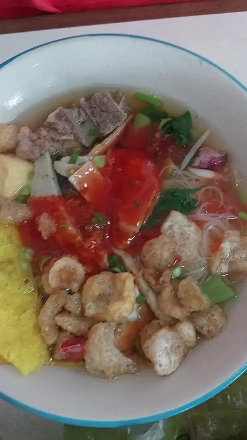 Tom yum noodle soup with sliced pork and pork crackling