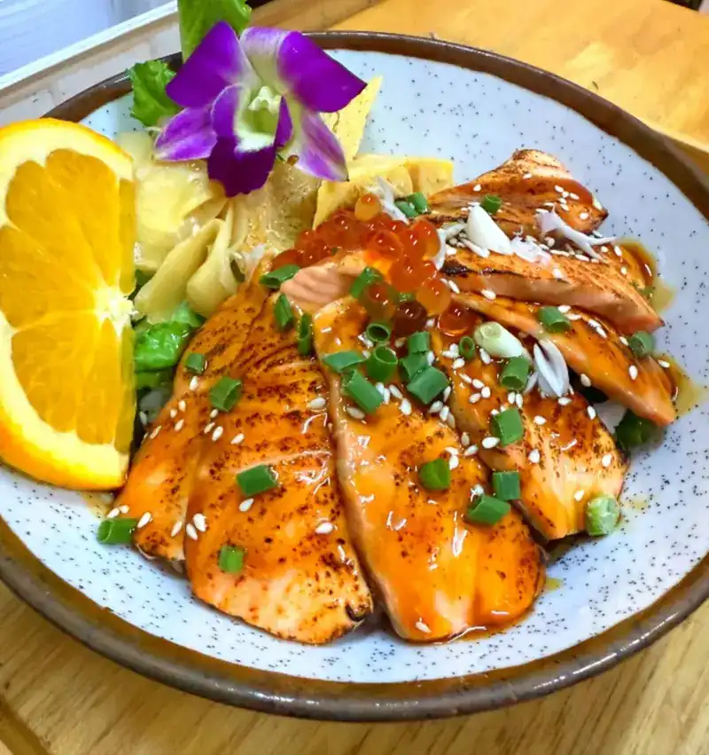 Flame-seared salmon rice bowl with salmon roe, spring onion and orange