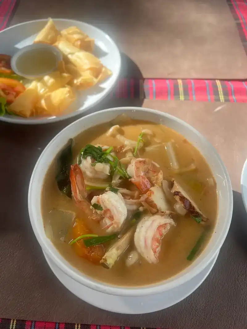 Creamy prawn soup with lemongrass and herbs, crispy wontons on the side