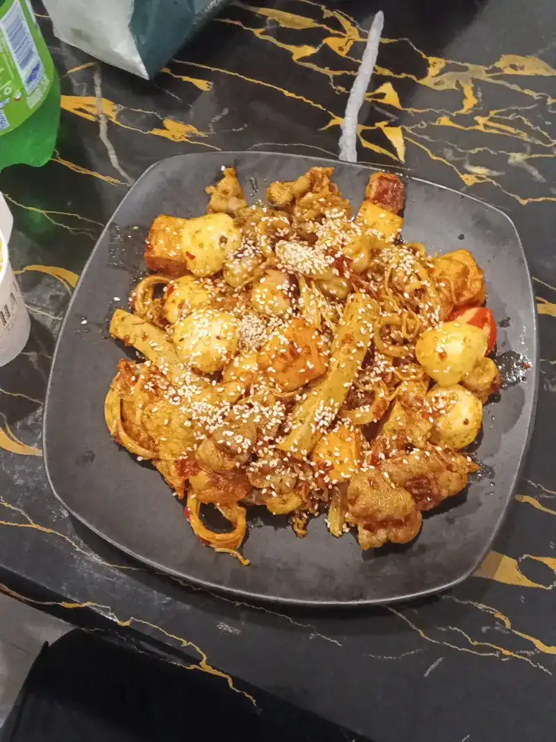 Dry mala with fish balls and sesame on a square black plate