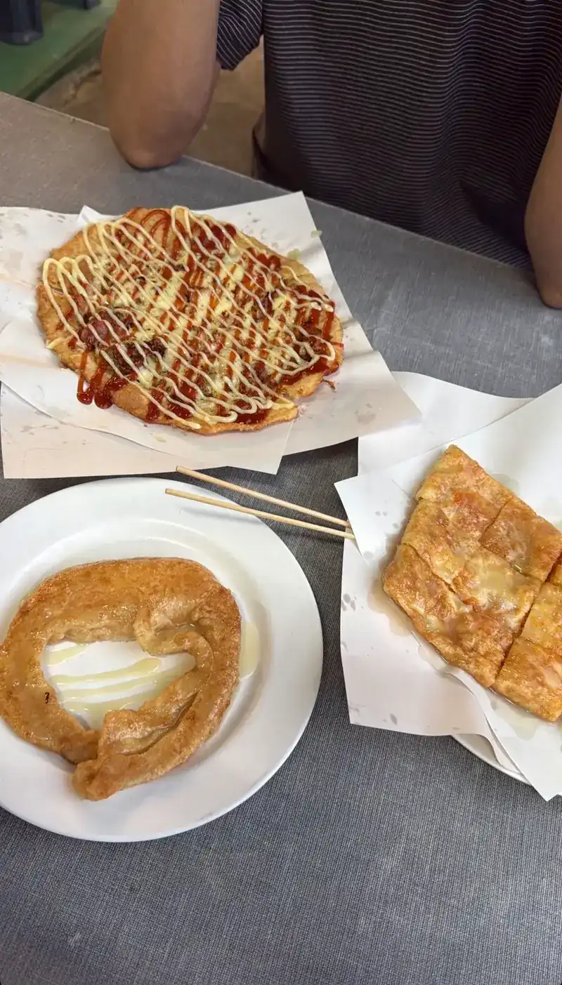 Pizza roti with sauce and mayonnaise, with two more roti beside it