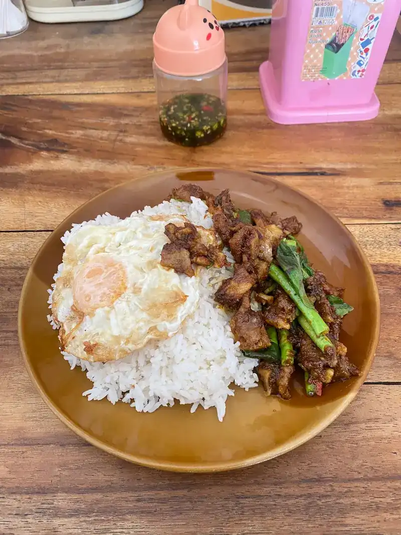 A stir-fry with Chinese kale and a fried egg over rice