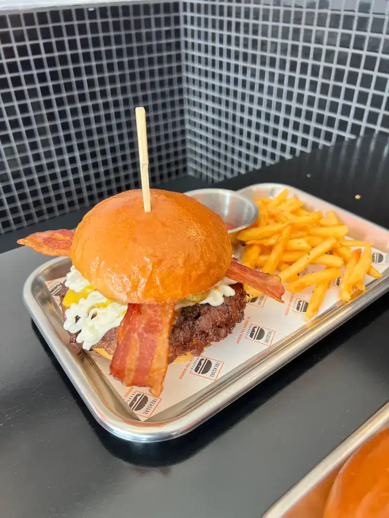 Bacon cheeseburger and fries on a steel tray / เบอร์เกอร์เบคอนชีสกับเฟรนช์ฟรายส์บนถาดสแตนเลส