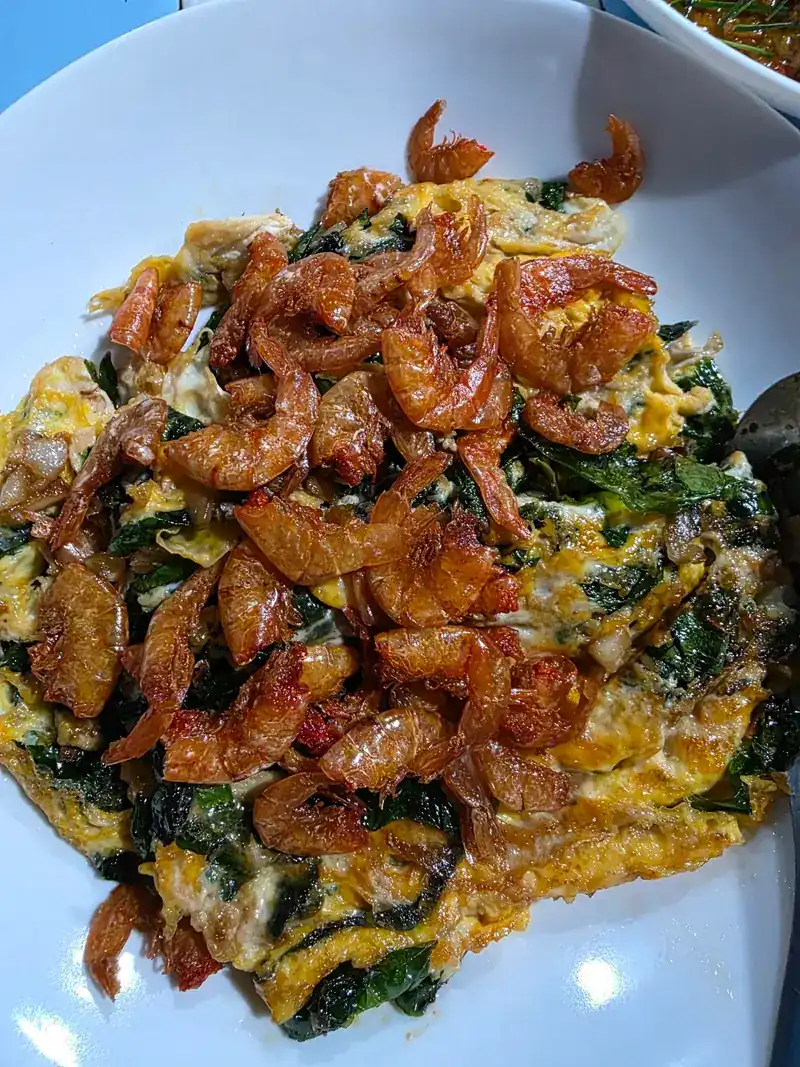 Egg fried with green leaves and crisp dried prawns