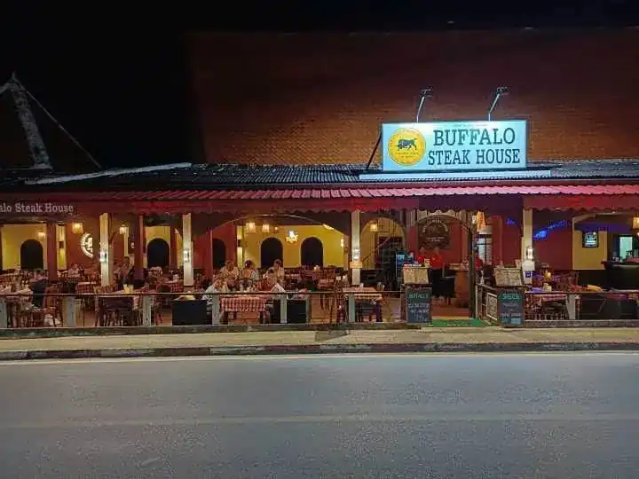 Buffalo Steakhouse on Karon Road at night, the terrace lit under the red awning