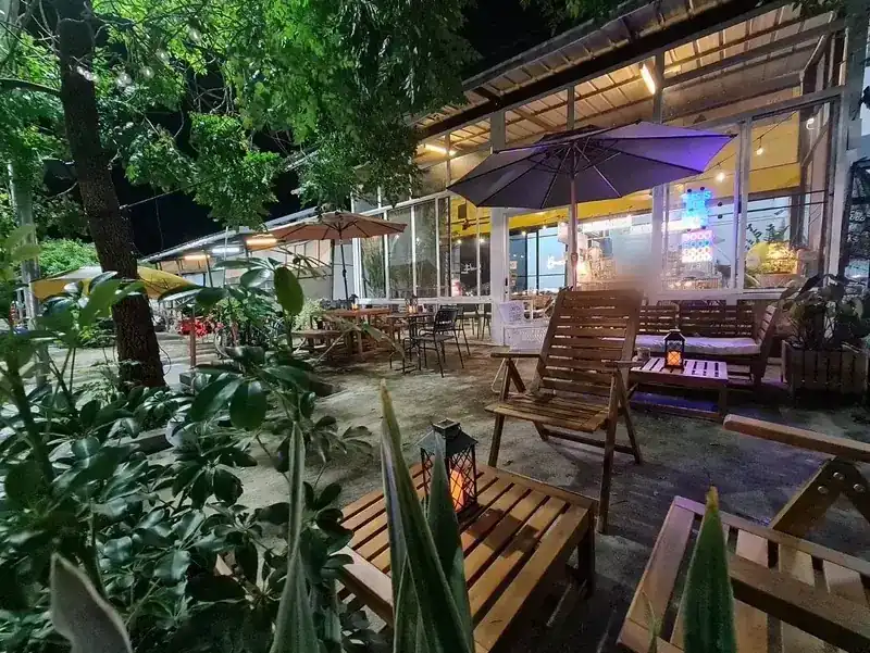 The garden terrace out front, with wooden chairs, lanterns and umbrellas