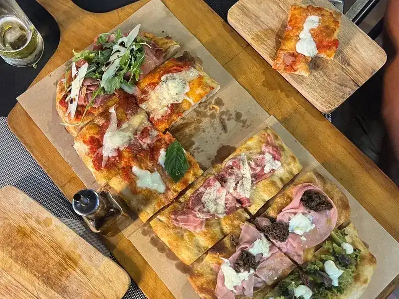 Slices of pizza alla pala on baking paper, seen from above