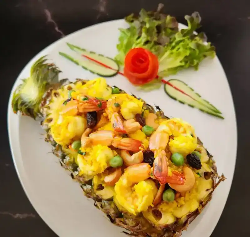 Pineapple baked rice with prawns and cashews served in a pineapple