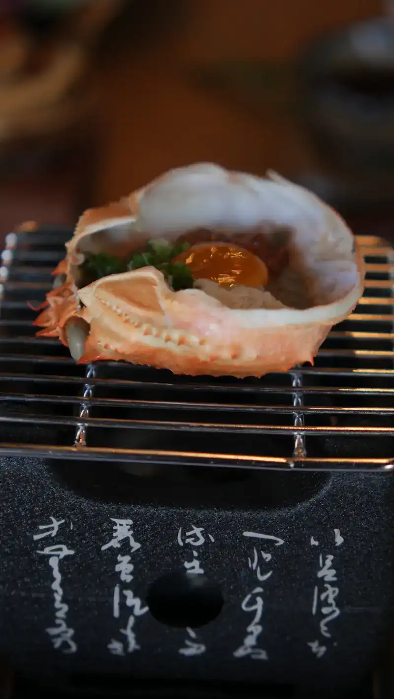 Crab shell warming on a small stove at the table / กระดองปูอุ่นบนเตาเล็กที่โต๊ะ