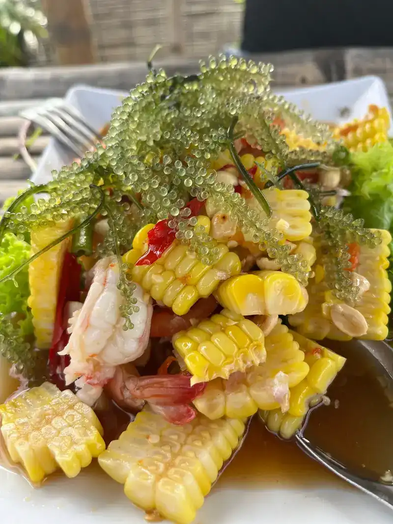 Sweetcorn salad topped with sea grapes and prawns