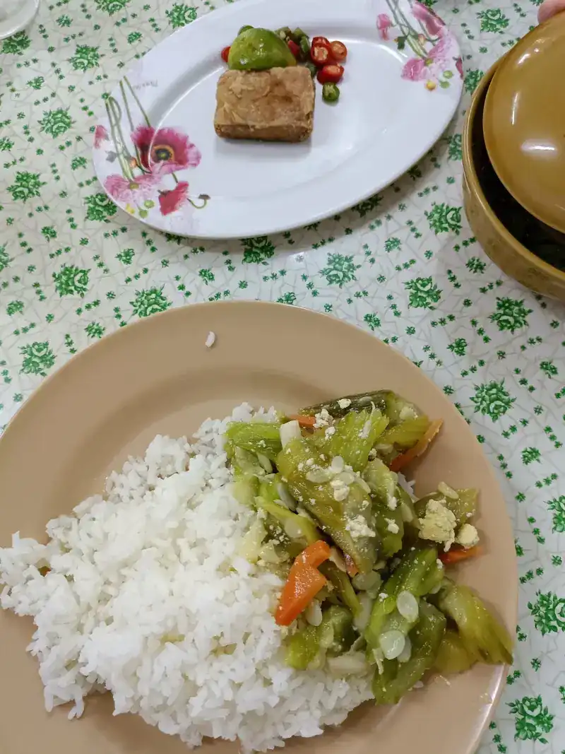Rice with stir-fried green vegetables, and a side plate with fresh chillies