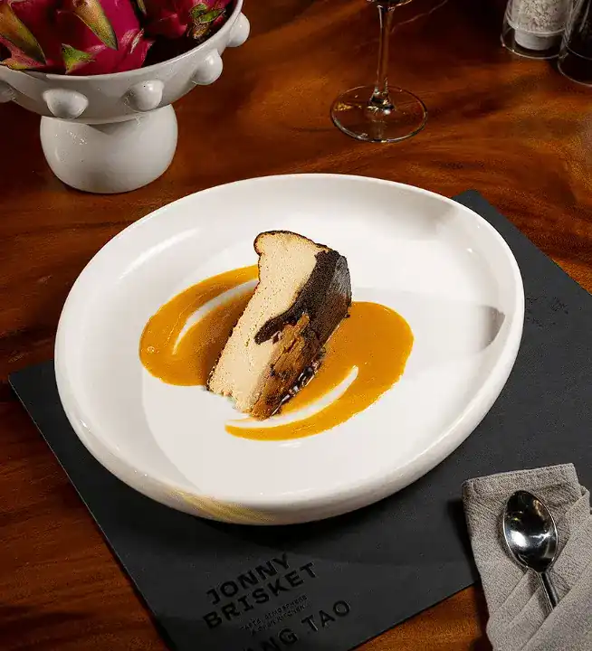 Coconut cheesecake with caramel sauce on a white plate